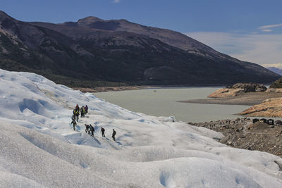 Scenic view of people on mountain against sky