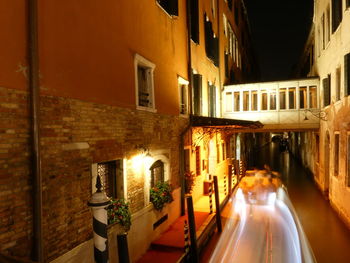 Illuminated buildings by street at night