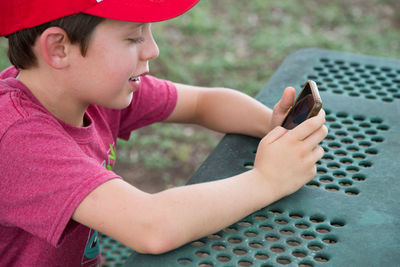 Side view of boy using mobile phone