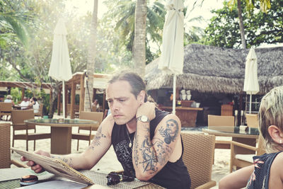 Man reading menu in outdoor restaurant