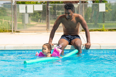 Father and daughter having fun in pool