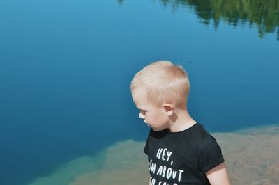 Boy standing against blue sea