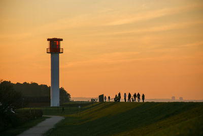 People on field against sky during sunset