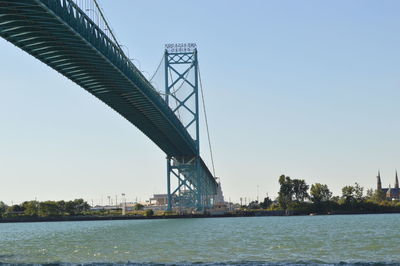 Low angle view of bridge over river against sky