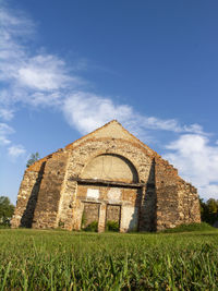 Exterior of temple on field against sky