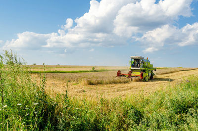 Tractor on agricultural field against sky