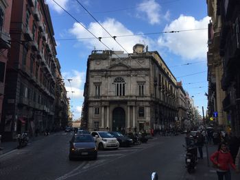 Cars on road in city against sky