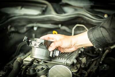 Cropped hand of man repairing car