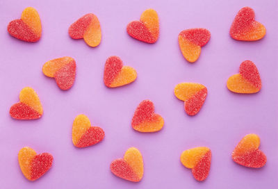 Heart shape candies on purple background