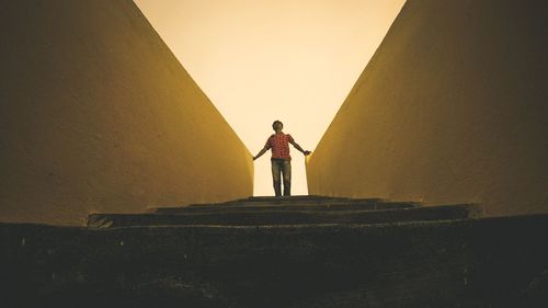 Rear view of woman standing against wall