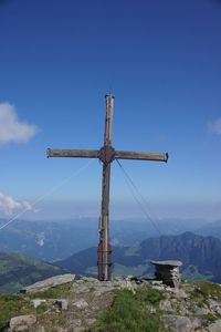 Windmill on mountain against blue sky