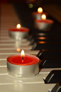 Close-up of tea light candle on piano