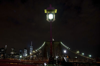 Illuminated street light in city at night