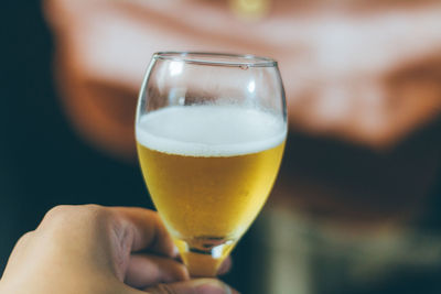Close-up of hand holding beer