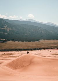 Mid distance of people on landscape against sky