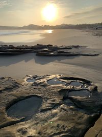 Scenic view of beach against sky during sunset