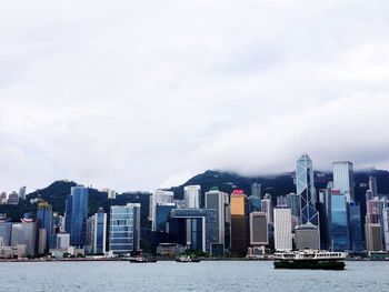 Sea by buildings against sky in city