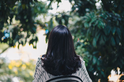 Rear view of woman against trees