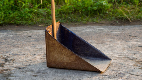 High angle view of wooden handle dust pan on footpath.