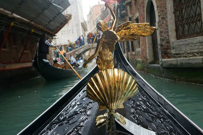 Statue by canal against buildings