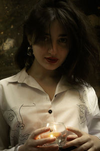 Close-up portrait of young woman having drink