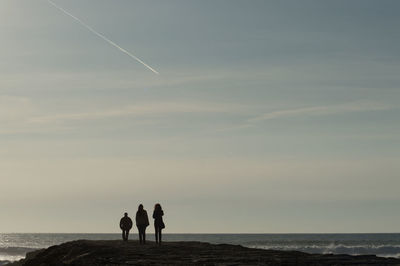 People at beach against sky