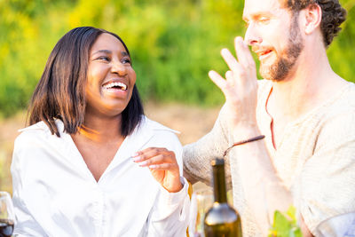 Joyful duo mixed race couple laughs amidst garden party festivities