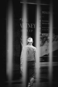 Rear view of man walking against blurred background