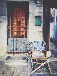 Old chair by closed doors on building