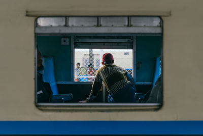 Rear view of man sitting in train