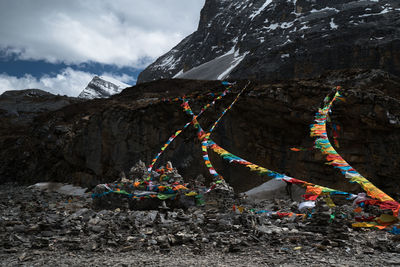 Multi colored flags on rock against sky during winter