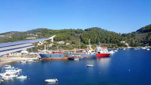 Boats sailing in sea against clear blue sky