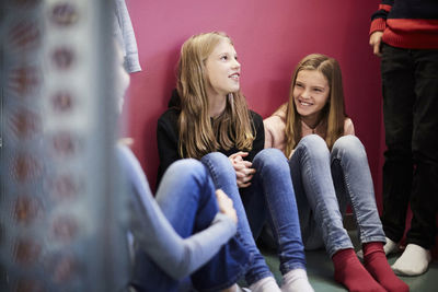 Smiling girls with friends in school building