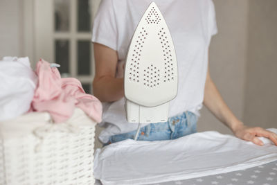 Midsection of woman standing on bed