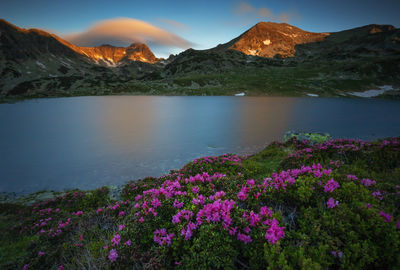 Scenic view of lake by mountain against sky