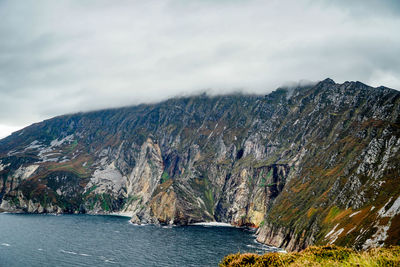 Scenic view of sea and mountains against sky