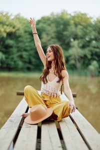 Young woman sitting on wooden table