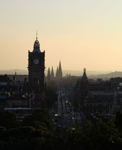 Buildings in city against sky during sunset