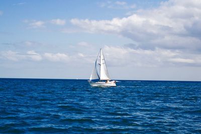 Sailboat sailing on sea against sky