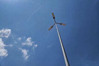 Low angle view of windmill against blue sky