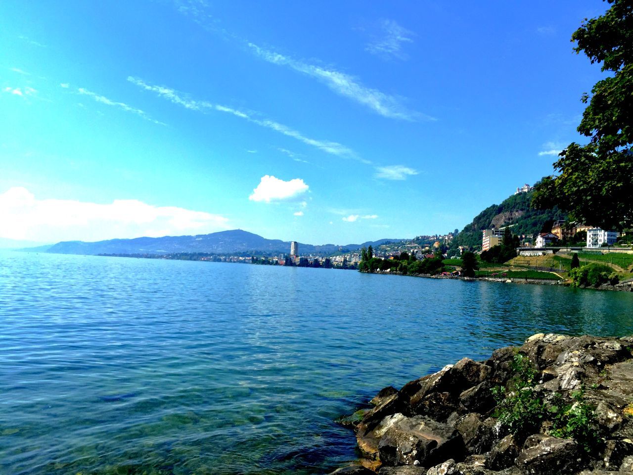 water, sky, blue, building exterior, built structure, architecture, mountain, tree, scenics, beauty in nature, tranquil scene, sea, nature, river, tranquility, cloud - sky, cloud, lake, waterfront, day