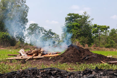Panoramic view of bonfire on landscape against sky
