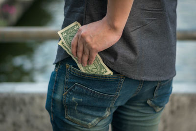 Midsection of man removing paper currency from pocket