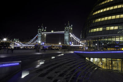 Illuminated bridge over river at night