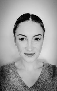 Portrait of smiling young woman against wall