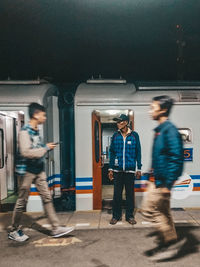 People walking on train in city