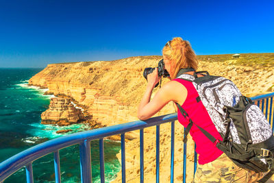 Woman photographing sea at kalbarri national park