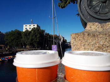 Close-up of tea by buildings against sky