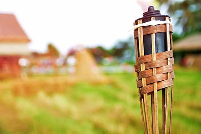 Close-up of wicker basket on field against sky