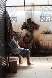 Man looking at camera while sitting on tiled floor